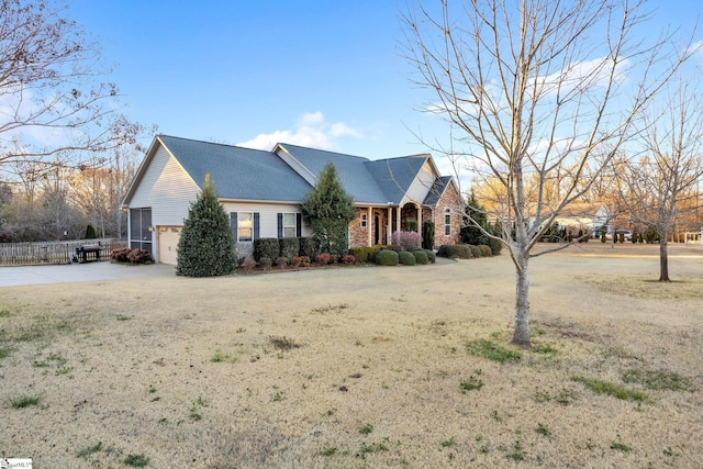 ranch-style home featuring driveway, an attached garage, fence, and brick siding