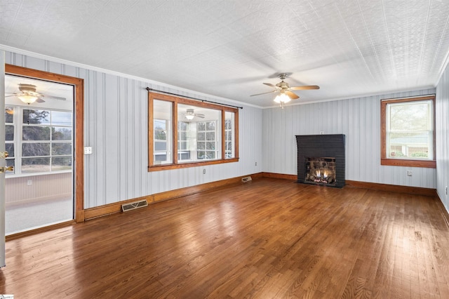 unfurnished living room featuring a fireplace, visible vents, and wood finished floors