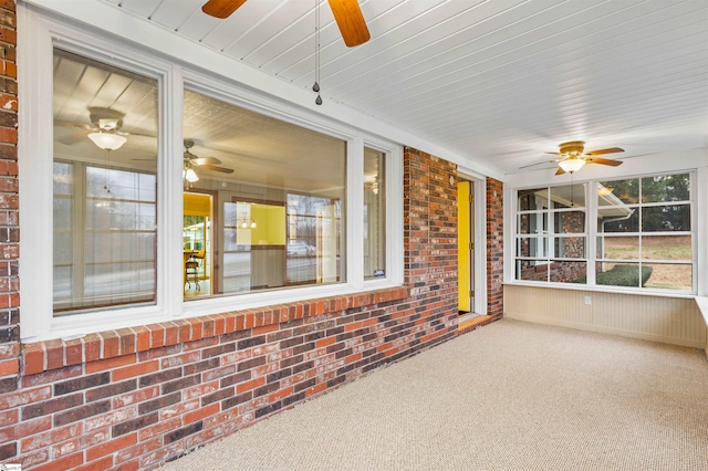 unfurnished sunroom featuring a ceiling fan