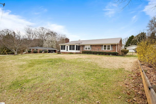 single story home featuring brick siding, a chimney, and a front lawn