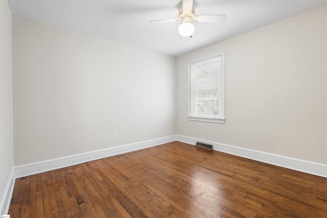 empty room with hardwood / wood-style flooring, baseboards, visible vents, and ceiling fan