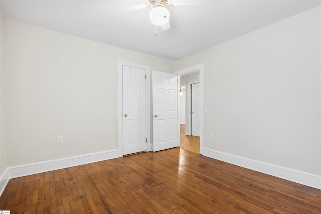 spare room with ceiling fan, baseboards, and hardwood / wood-style flooring