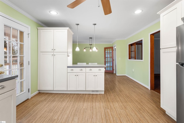 kitchen with light wood-type flooring, white cabinetry, and ornamental molding