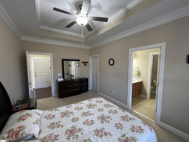 bedroom with baseboards, a tray ceiling, ornamental molding, and light colored carpet