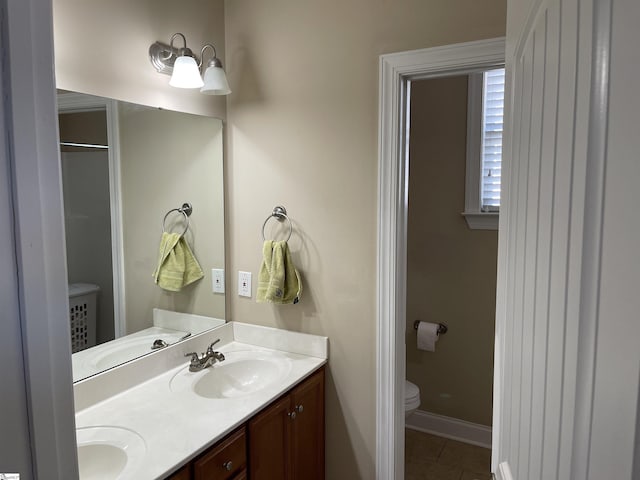 bathroom with tile patterned flooring, a sink, toilet, and double vanity