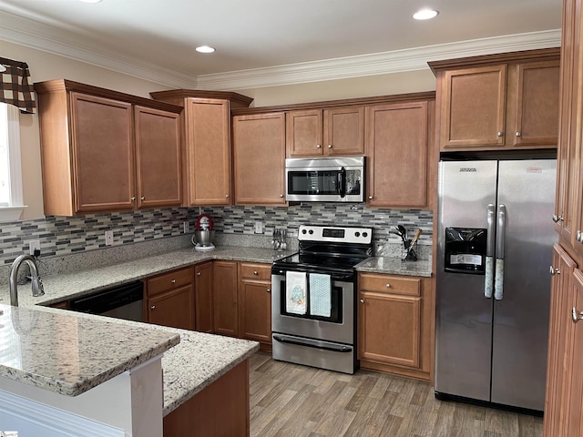 kitchen featuring light stone counters, stainless steel appliances, backsplash, light wood-style floors, and ornamental molding