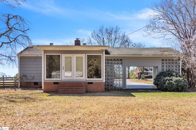 view of front facade with roof with shingles, a chimney, a front yard, crawl space, and fence