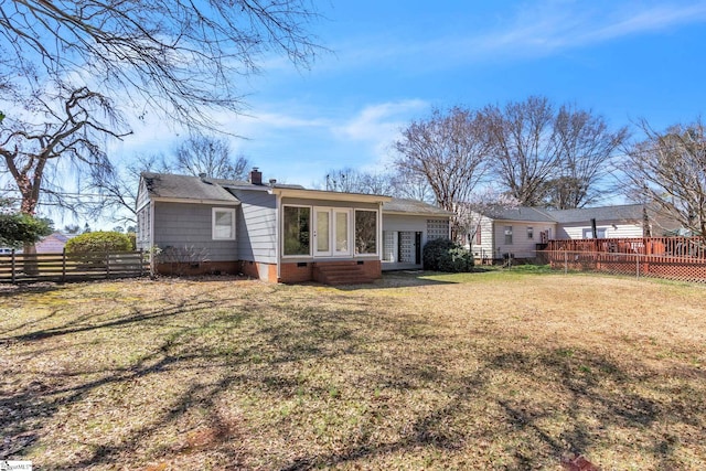 back of property featuring entry steps, fence, a yard, crawl space, and a chimney