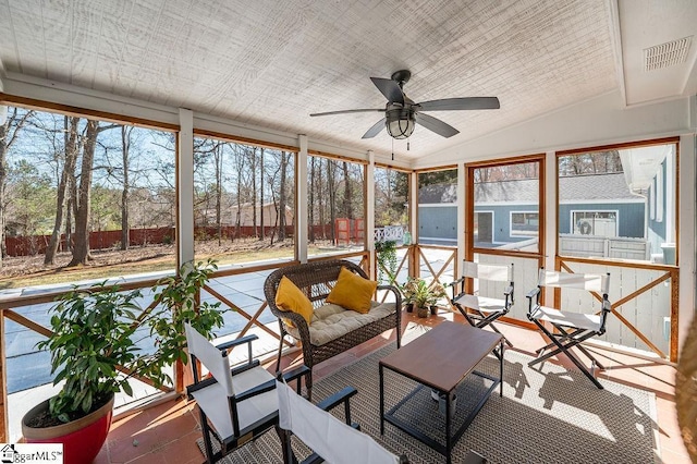 unfurnished sunroom featuring ceiling fan and vaulted ceiling