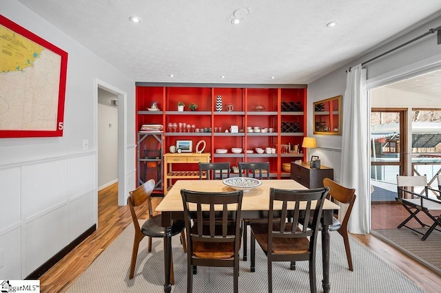 dining space featuring recessed lighting, a textured ceiling, and wood finished floors