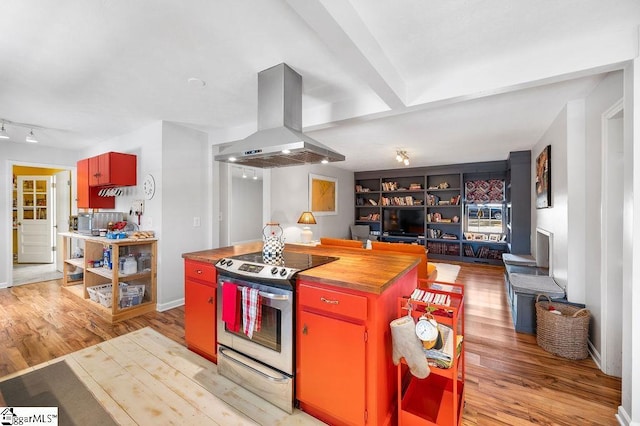 kitchen with light wood-style floors, butcher block counters, island range hood, and electric stove