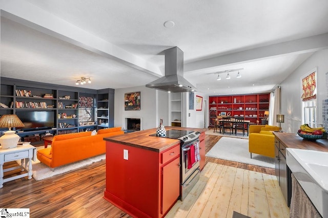 kitchen featuring butcher block counters, stainless steel electric range oven, open floor plan, and island exhaust hood