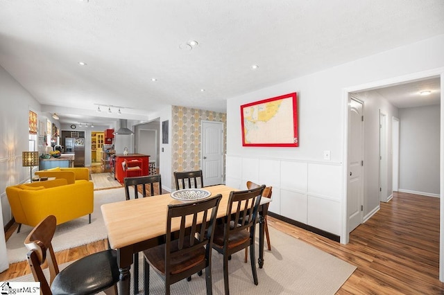 dining room with light wood-style floors, recessed lighting, rail lighting, and baseboards