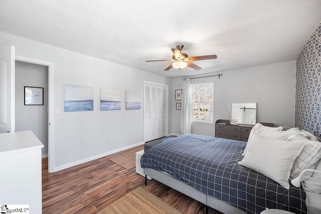 bedroom with ceiling fan, a closet, wood finished floors, and baseboards