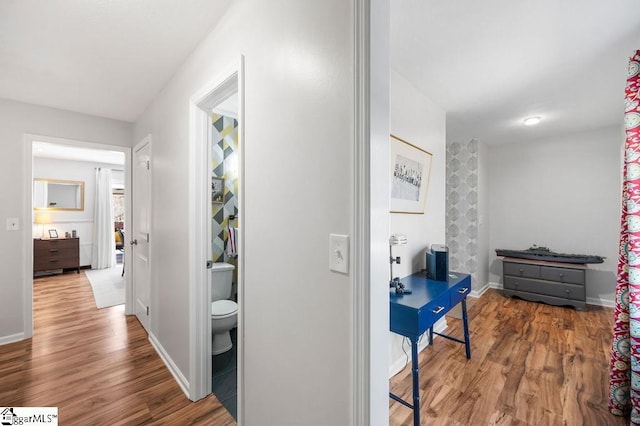 hall with baseboards and wood finished floors