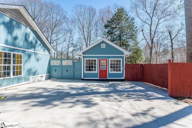 view of outbuilding with fence, driveway, and an outdoor structure