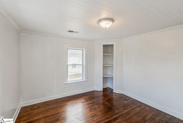 unfurnished room featuring dark wood-type flooring, visible vents, built in features, baseboards, and ornamental molding