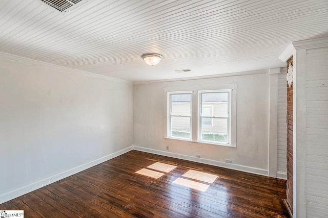 unfurnished room featuring baseboards, visible vents, hardwood / wood-style floors, and ornamental molding