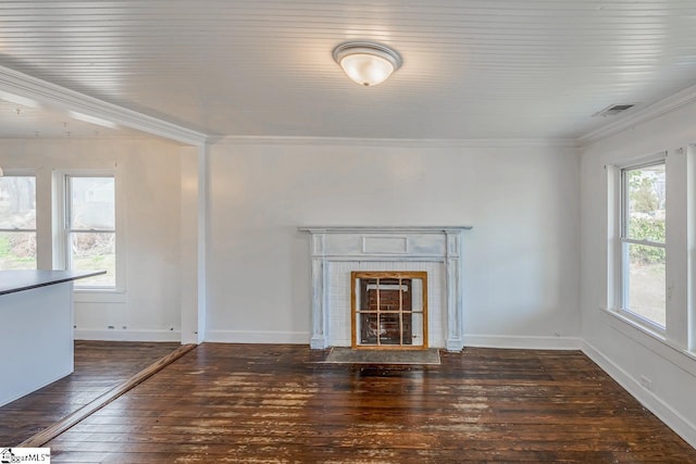 unfurnished living room with a wealth of natural light, a fireplace, hardwood / wood-style flooring, and crown molding