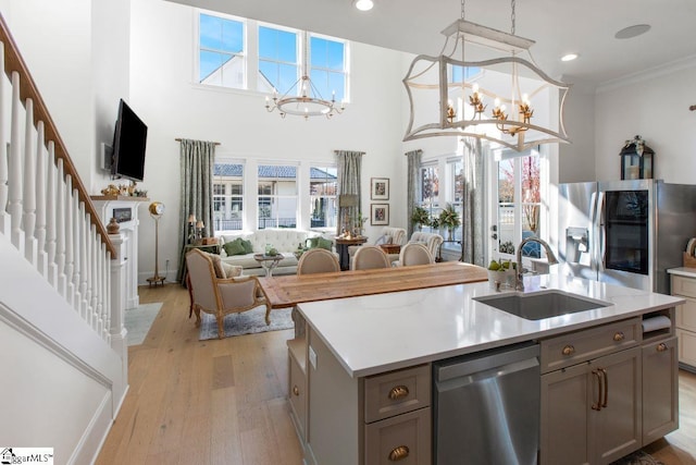 kitchen with appliances with stainless steel finishes, a chandelier, a sink, and gray cabinetry