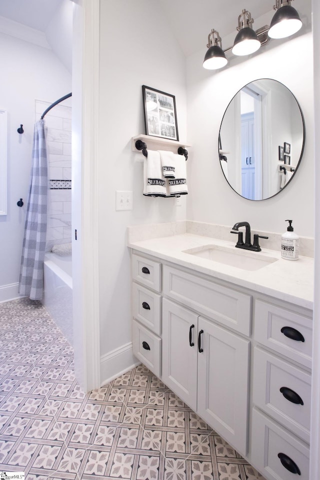 full bathroom with vaulted ceiling, tile patterned floors, vanity, and baseboards