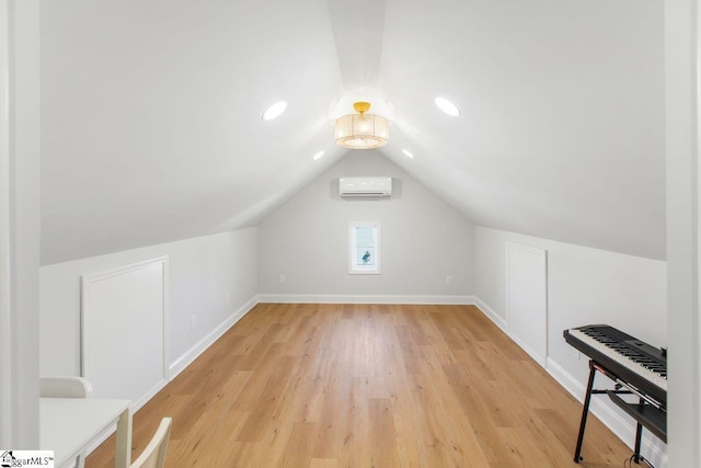 additional living space with a wall unit AC, light wood-style flooring, recessed lighting, baseboards, and vaulted ceiling