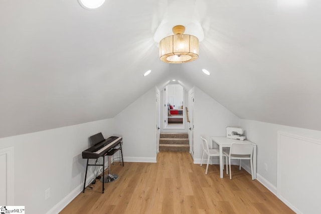 additional living space featuring light wood-type flooring, baseboards, and lofted ceiling