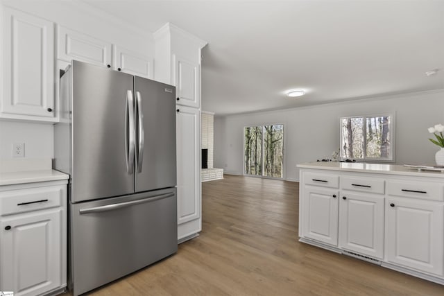 kitchen with white cabinetry, open floor plan, light countertops, light wood-type flooring, and freestanding refrigerator