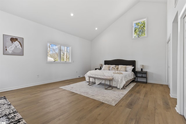 bedroom with multiple windows, baseboards, and wood finished floors