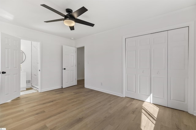 unfurnished bedroom with baseboards, light wood finished floors, a closet, and crown molding