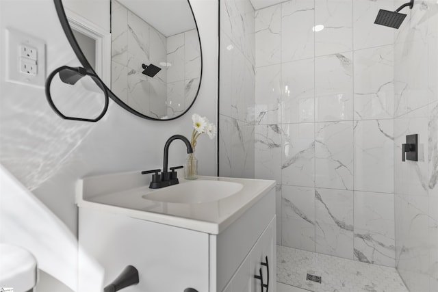 bathroom featuring vanity and a marble finish shower