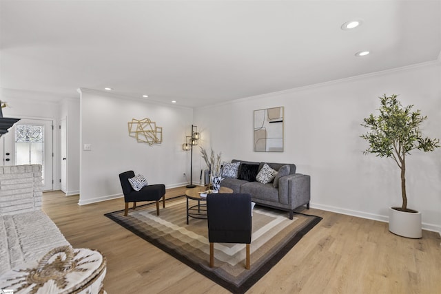 living area featuring light wood-style flooring, baseboards, and crown molding