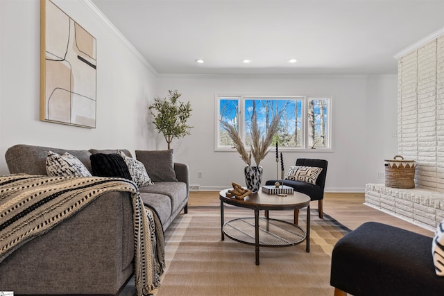 living area with ornamental molding, recessed lighting, light wood-style floors, and baseboards