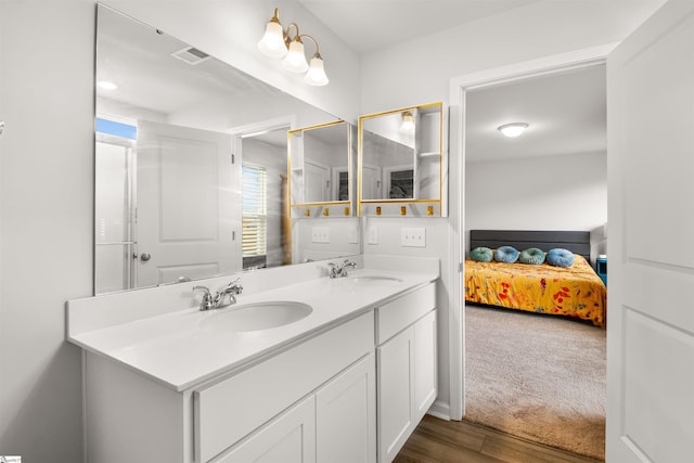 bathroom with double vanity, visible vents, a sink, and ensuite bathroom