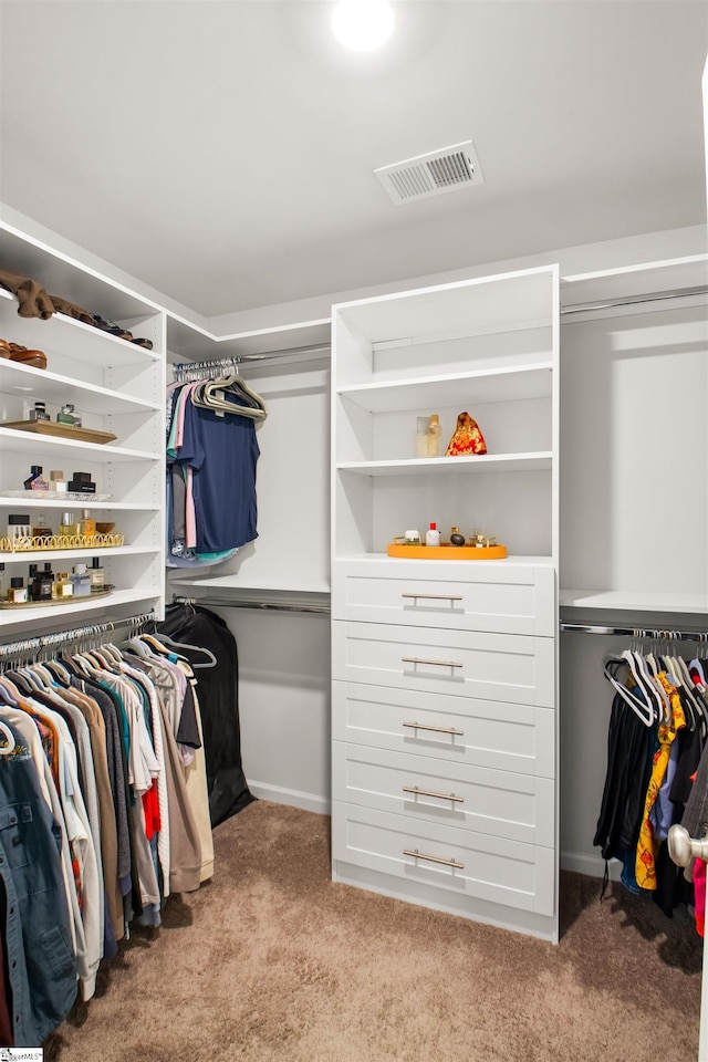 walk in closet with visible vents and light carpet