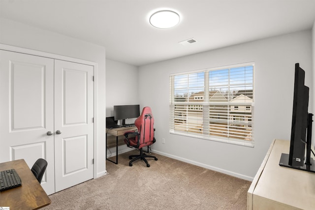 office featuring baseboards, visible vents, and light colored carpet