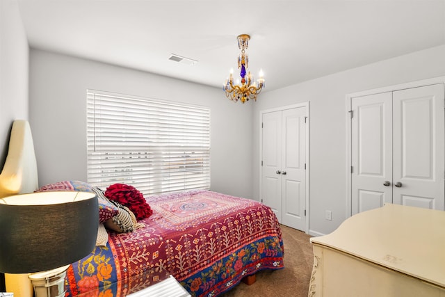 carpeted bedroom with multiple closets, visible vents, and a notable chandelier