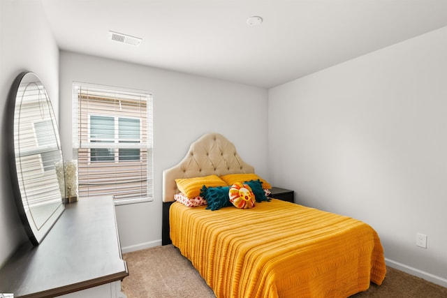 bedroom featuring baseboards, visible vents, and light colored carpet