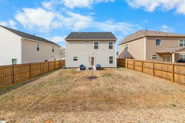 rear view of house with a fenced backyard