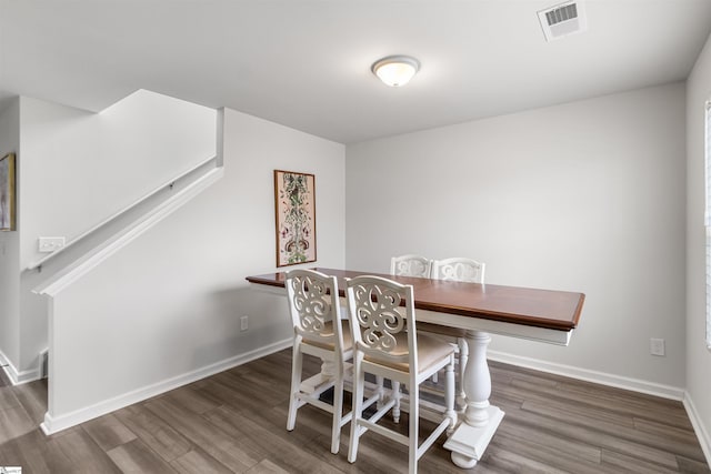 dining room featuring visible vents, stairs, baseboards, and wood finished floors