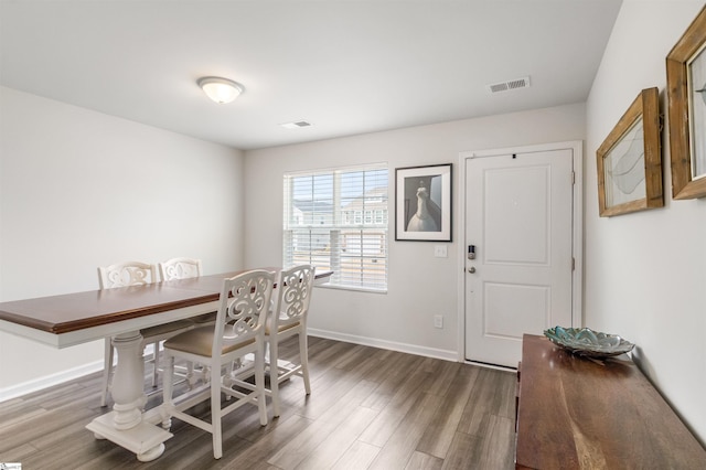 dining area with wood finished floors, visible vents, and baseboards