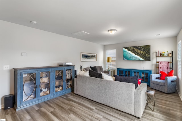 living area with plenty of natural light, wood finished floors, and visible vents