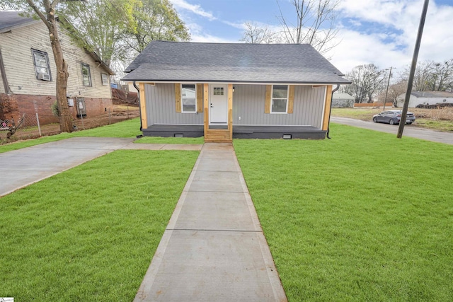 bungalow with crawl space, covered porch, a shingled roof, and a front yard