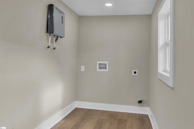 laundry room with hookup for a washing machine, laundry area, wood finished floors, baseboards, and electric dryer hookup