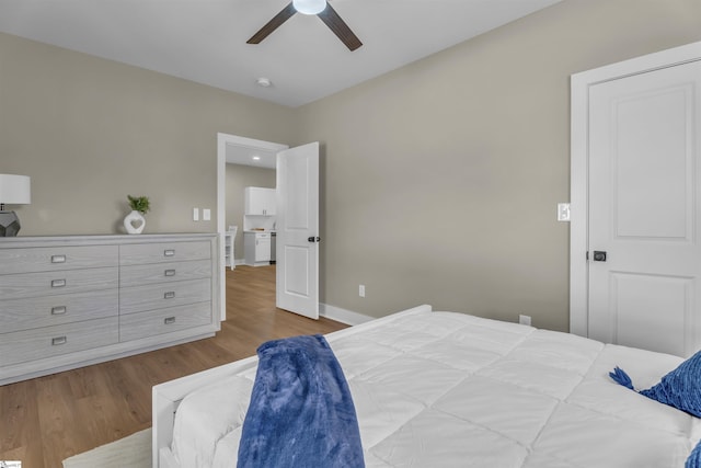 bedroom with ceiling fan, baseboards, and wood finished floors