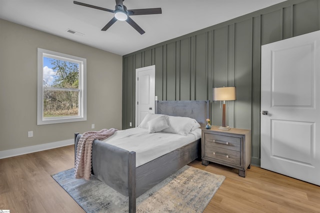 bedroom with light wood-type flooring, baseboards, visible vents, and a ceiling fan