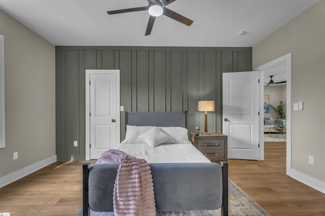 bedroom with ceiling fan, baseboards, and wood finished floors