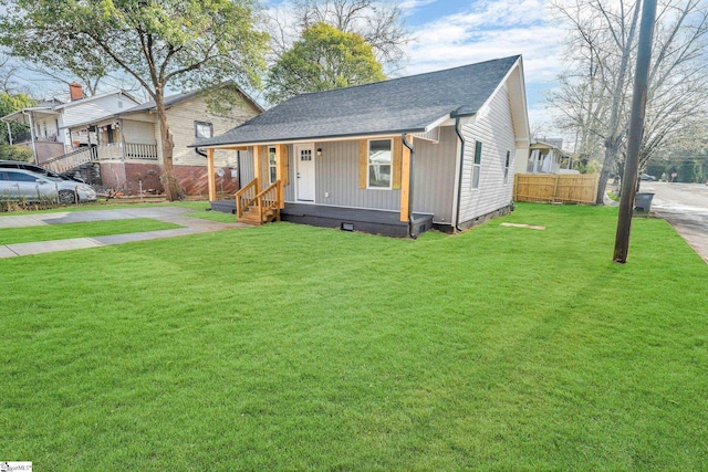 view of front of property with covered porch, a front lawn, crawl space, and fence