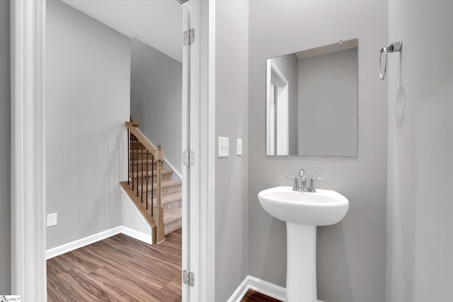 bathroom with a sink, baseboards, and wood finished floors