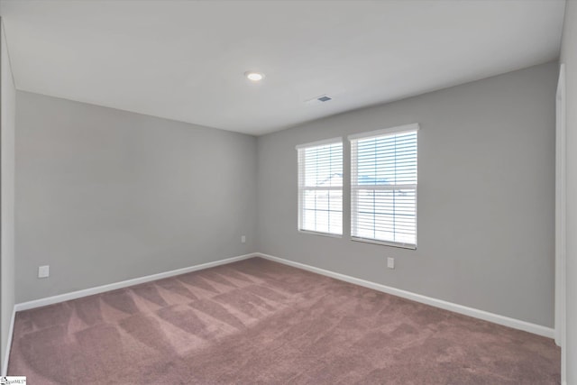 unfurnished room featuring carpet floors, visible vents, and baseboards